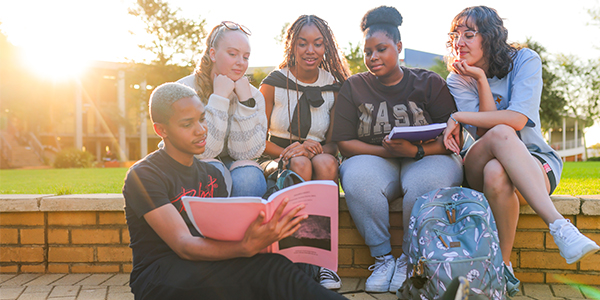 Group of Wits students looking at a book